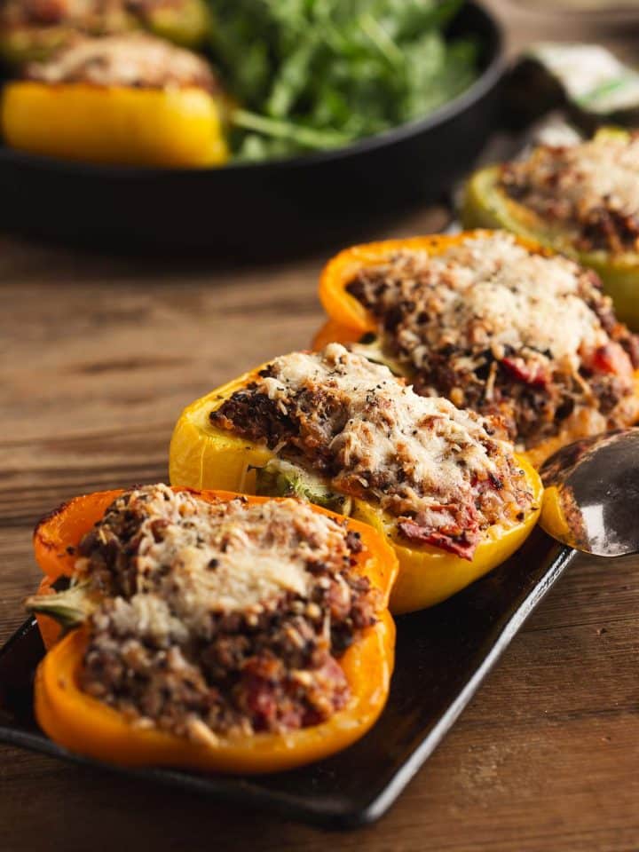 Angled photograph of the stuffed peppers without rice side by side on a rectangular plate.